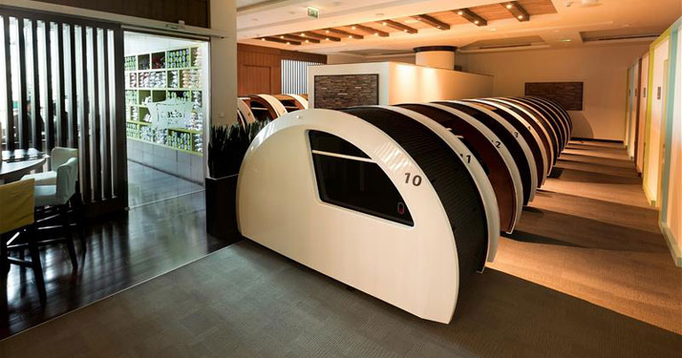 Timber sleeping cabins with solid doors built as a block inside an airport concourse