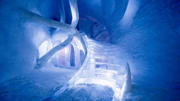 A corridor carved from snow with light coming through the ice walls
